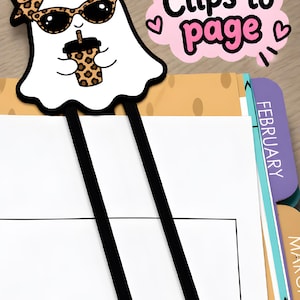 Leopard bow girl ghost bookmark clipped onto a planner page, showing how the long paperclip-style 3D printed bookmark holds a page.