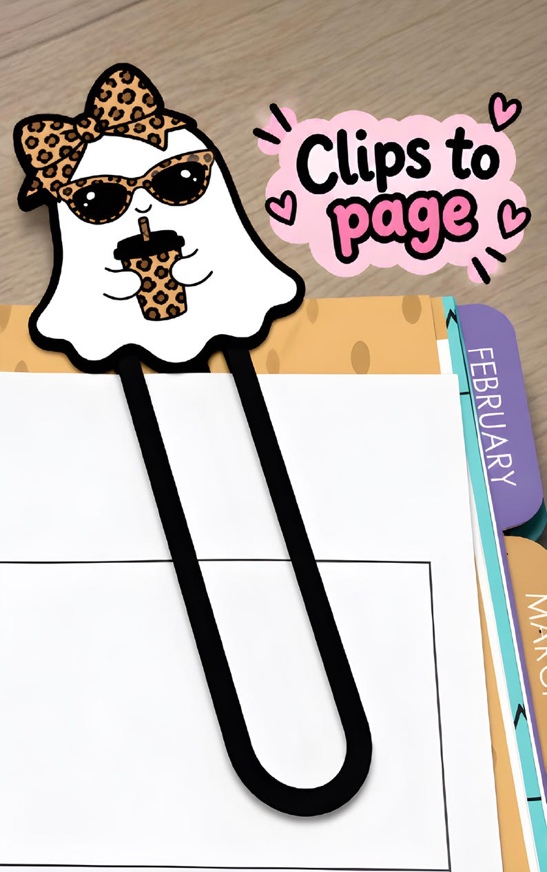 Leopard bow girl ghost bookmark clipped onto a planner page, showing how the long paperclip-style 3D printed bookmark holds a page.