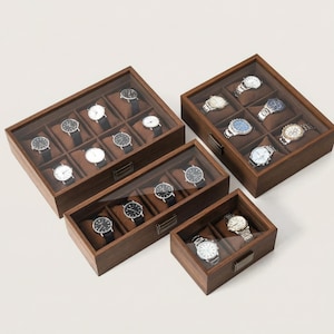 May include: Several wooden watch display cases with glass lids. The cases are filled with various wristwatches, each resting on a brown cushion. The cases vary in size and are arranged on a white surface.