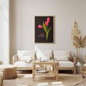 May include: A framed art print featuring three pink tulips with green leaves against a black background. The word "TULIP" is displayed in white text. The artwork hangs above a light-colored sofa in a living room setting.