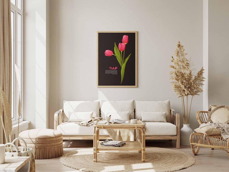 May include: A framed art print featuring three pink tulips with green leaves against a black background. The word "TULIP" is displayed in white text. The artwork hangs above a light-colored sofa in a living room setting.