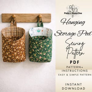 May include: Two fabric hanging storage pods, one brown with floral print, the other green with floral print, suspended from a wooden rack. The image includes text that reads "Hanging Storage Pod Sewing Pattern PDF".