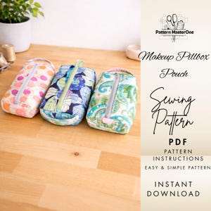 May include: Three fabric makeup pillbox pouches with zip closures. The pouches feature different patterns: pink polka dots, blue floral, and green paisley. The image also includes text that says "Makeup Pillbox Pouch Sewing Pattern PDF".