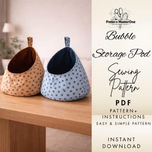 May include: Two fabric storage pods with handles sit on a wooden table. One pod is tan with small brown floral patterns, and the other is light blue with dark blue floral patterns. The pods are open at the top and have a rounded shape. Text on the right says "Bubble Storage Pod Sewing Pattern".