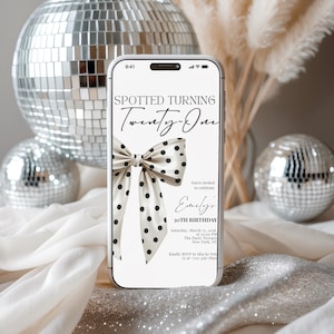 May include: A smartphone displaying a digital birthday invitation with the text Spotted Turning Twenty-One, featuring a cream-colored bow with black polka dots. The invitation includes details for Emily's 30th birthday on Saturday, March 13, 2026.