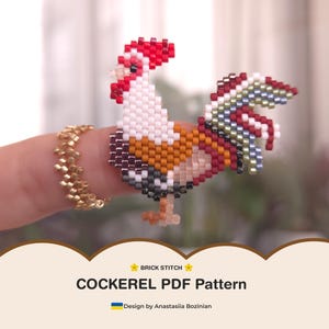 Puede incluir: Una figura de gallo de cuentas en rojo, blanco, naranja y negro. El gallo está posado en un dedo, con un anillo dorado. La imagen incluye el texto "COCKEREL PDF Pattern" y "Design by Anastasiia Bozinian".