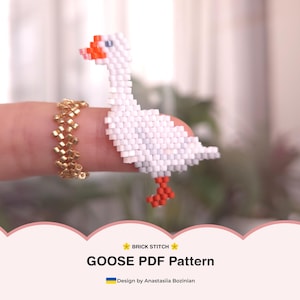 Może przedstawiać: Biała gęś z koralików z pomarańczowym dziobem i stopami. Gęś wykonana techniką ściegu cegiełkowego. Widoczny jest również złoty pierścionek z koralików. Obraz zawiera tekst "GOOSE PDF Pattern" i "Design by Anastasiia Bozinian".