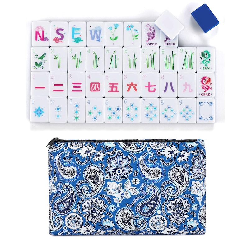 May include: A white Mahjong set with colorful tiles featuring Chinese characters, symbols, and illustrations. The set includes a blue paisley-patterned carrying case. The tiles are arranged on a white surface.