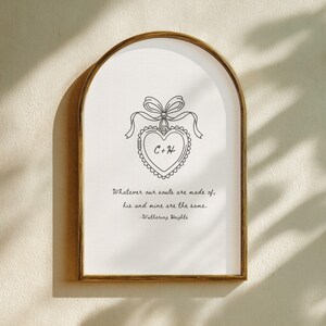 Vintage frame displays a Wuthering Heights print with the quote 'Whatever our souls are made of, his and mine are the same." A concept rendering of a locket with "C" and "H" for the main characters is in the middle.