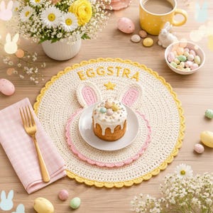 May include: A crocheted Easter bunny placemat with the word "EGGSTRA" in yellow. A small cake with pastel-colored eggs sits on a white plate. A gold fork and pink napkin are on the left. The scene is decorated with flowers and Easter eggs.