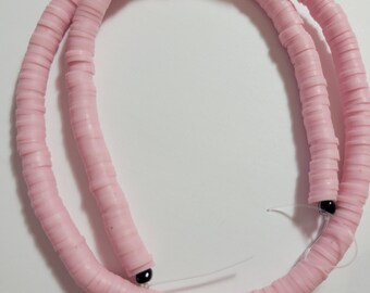May include: A strand of pink polymer clay beads, with a black bead at each end.