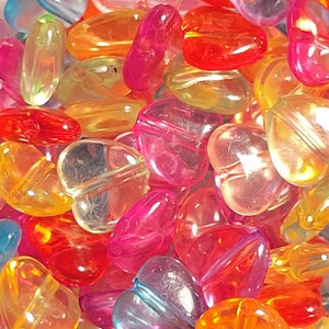 May include: Assortment of colorful heart-shaped beads made of clear plastic. The beads are translucent and have a variety of colors, including red, orange, yellow, green, blue, and purple.