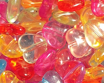 May include: Assortment of colorful heart-shaped beads made of clear plastic. The beads are translucent and have a variety of colors, including red, orange, yellow, green, blue, and purple.