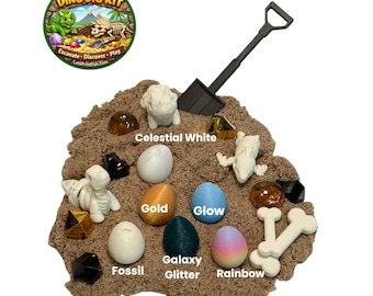 May include: A Dino Dig Kit with a variety of colorful eggs, dinosaur figurines, and a small shovel. The kit includes eggs labeled "Glow", "Galaxy Glitter", and "Rainbow". The kit's logo reads "Let's Print Dino Dig Kit".