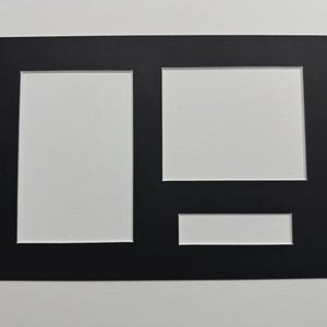 May include: A black picture mount with three rectangular apertures. The mount is designed to hold multiple photos or artwork, with a large rectangular aperture and two smaller ones.