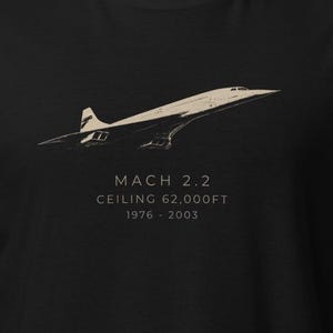 Könnte beinhalten: Ein schwarzes T-Shirt mit einer beigen Grafik des Überschallflugzeugs Concorde. Unter dem Flugzeug steht der Text: MACH 2.2, CEILING 62,000FT, 1976 - 2003. Das Design ist mittig auf der Brust platziert und zeigt das ikonische Deltaflügel-Profil.