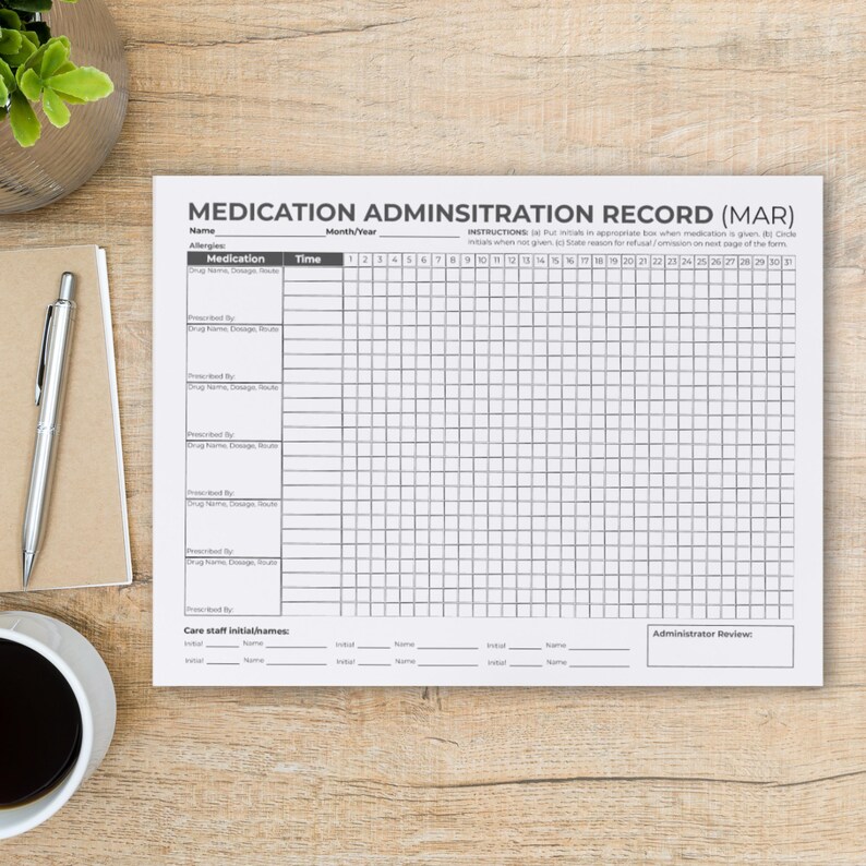 Puede incluir: Un formulario de registro de administraci&oacute;n de medicamentos (MAR) sobre una superficie de madera. El papel blanco tiene una cuadr&iacute;cula para el seguimiento de medicamentos, con secciones para nombre, medicamento, hora y fechas. El t&iacute;tulo "MEDICATION ADMINSITRATION RECORD (MAR)" est&aacute; en la parte superior.