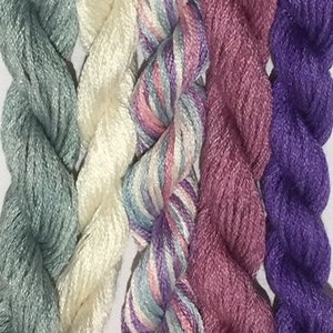 Peut inclure: Cinq bobines de fil à broder de différentes couleurs, dont bleu clair, crème, multicolore, rose et violet.