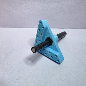 May include: A light blue, triangular tool with multiple small holes, holding a black cylindrical object. The tool appears to be 3D-printed. The black object has a metallic end. The item is set against a white background.