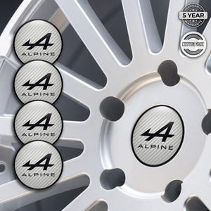 May include: Silver car wheel with four Alpine logo center caps. The caps have a carbon fiber pattern and the Alpine logo in black. The wheel has a 5-year warranty and is custom made.