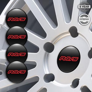 Könnte beinhalten: Schwarze Radnabenkappen mit dem roten "RAYS"-Logo. Die Kappen werden vor einer silbernen Felge mit mehreren Speichen gezeigt. Das Bild enthält auch ein "5 YEAR WARRANTY" und "CUSTOM MADE"-Abzeichen.