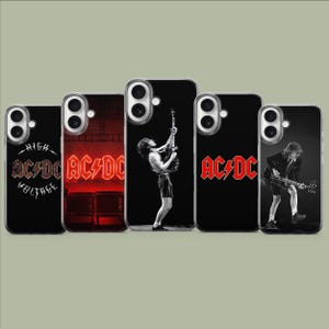 Puede incluir: Cinco fundas para smartphone con imágenes de la banda AC/DC. Los diseños incluyen el logotipo de High Voltage, una escena de escenario roja, la silueta de un guitarrista en blanco y negro, el logo rojo de AC/DC y un guitarrista en traje.