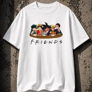 May include: White t-shirt featuring a graphic of anime characters eating together, with the word "FRIENDS" in colorful letters below. The design is reminiscent of the popular TV show. A casual, comfortable tee.