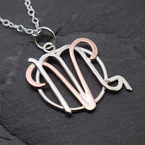 May include: Silver necklace with a rose gold Virgo zodiac sign pendant.