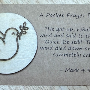 May include: A Pocket Prayer for Peace card. The card features a wooden dove holding an olive branch, set on a light brown background. Text includes a Bible verse from Mark 4:39 about peace and calmness.