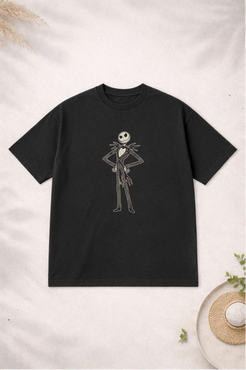 Puede incluir: Camiseta negra de cuello redondo con una ilustraci&oacute;n de dibujos animados de Jack Skellington de Pesadilla antes de Navidad. El personaje est&aacute; representado con su traje caracter&iacute;stico con los brazos en jarras. Una camiseta divertida para los fans de la pel&iacute;cula.