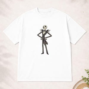 Puede incluir: Camiseta blanca con una ilustraci&oacute;n de Jack Skellington de Pesadilla antes de Navidad. El personaje est&aacute; representado con su traje blanco y negro, con los brazos cruzados. Un dise&ntilde;o cl&aacute;sico para los fans de la pel&iacute;cula.