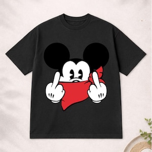 May include: Black t-shirt featuring a cartoon mouse with large black ears, a red bandana, and white gloves giving the middle finger. The graphic is centered on the shirt. The shirt has short sleeves and a crew neck.