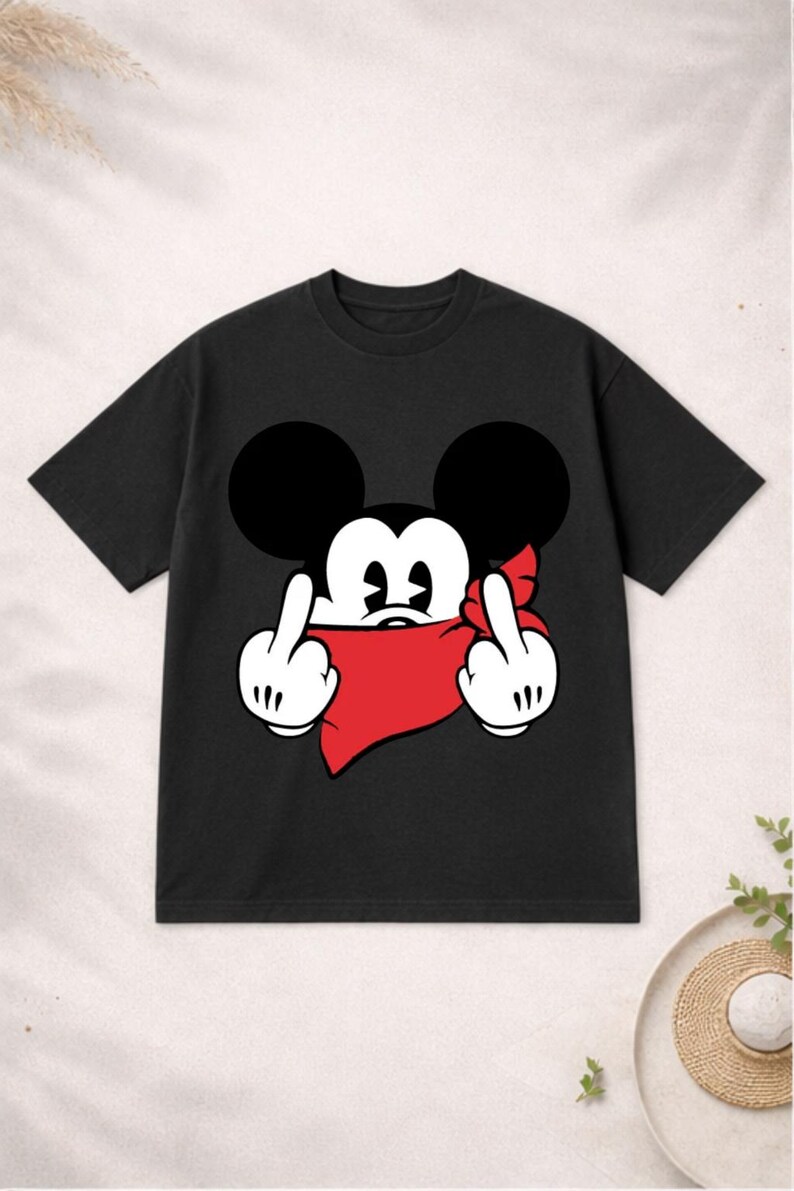 May include: Black t-shirt featuring a cartoon mouse with large black ears, a red bandana, and white gloves giving the middle finger. The graphic is centered on the shirt. The shirt has short sleeves and a crew neck.