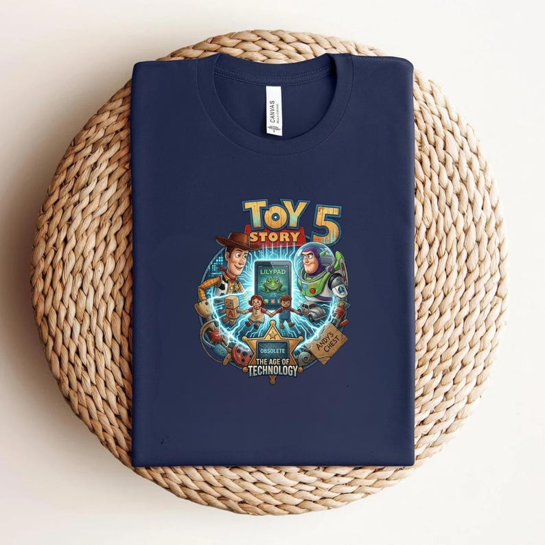 May include: Navy blue t-shirt featuring a colorful graphic from the movie Toy Story 5. The design includes Woody, Buzz Lightyear, and other characters. The text "TOY STORY 5" is prominently displayed, along with the text "OBSOLETE THE AGE OF TECHNOLOGY".