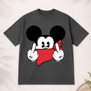 May include: Dark gray t-shirt featuring a cartoon character with large black ears and a red bandana. The character is giving the middle finger with both hands. A humorous and edgy graphic tee.