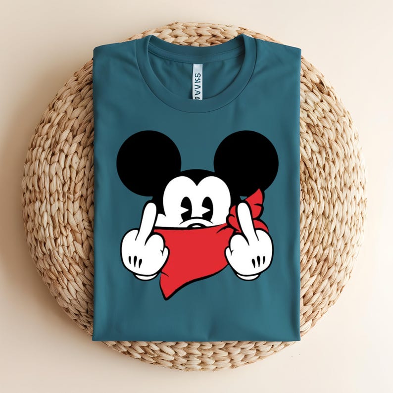 May include: Teal t-shirt featuring a cartoon mouse character with black ears, a red bandana, and white gloves, giving the middle finger with both hands. The design is centered on the shirt.