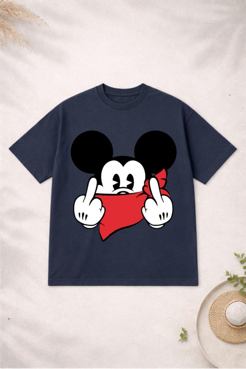 May include: Navy blue t-shirt featuring a cartoon mouse with black ears, white gloves, and a red bandana. The mouse is giving the middle finger with both hands. A humorous and edgy graphic tee.
