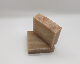 May include: Two bars of handmade soap, one on top of the other. The soap is a light brown color with a marbled pattern.