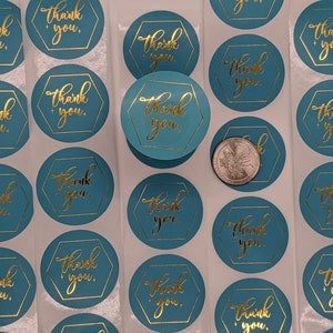May include: A sheet of turquoise blue round stickers with gold foil lettering that says "Thank You" in a hexagon shape.