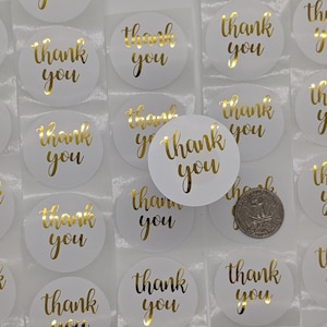May include: A sheet of white round stickers with gold foil lettering that says "Thank You".