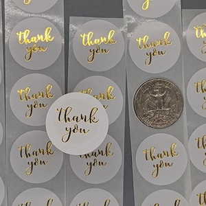 May include: A sheet of white round stickers with gold foil lettering that says "Thank You".
