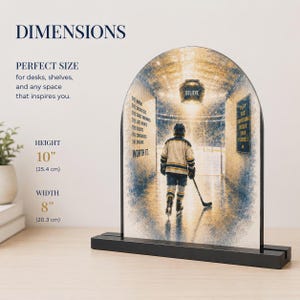 Peut inclure: Une plaque en acrylique arquée représentant un joueur de hockey dans un tunnel, avec le texte 'Believe' et 'Worth it'. La plaque mesure 25,4 cm de hauteur et 20,3 cm de largeur, et est fixée sur un socle rectangulaire noir.