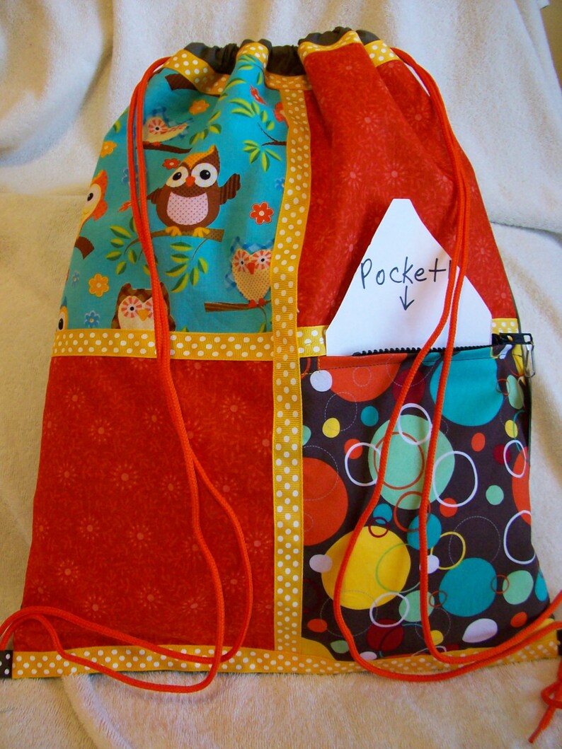 owls with orange and gold accents on a brown ripstop nylon drawstring backpack with front zipper pocket