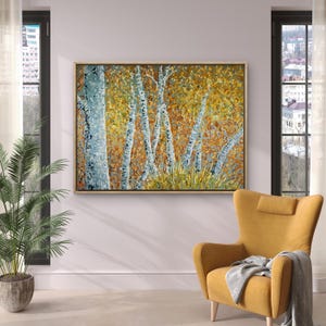 Könnte beinhalten: Abstrakte Malerei von Birken mit weißer und grauer Rinde, vor einem Hintergrund aus goldenem und orangefarbenem Laub. Das Kunstwerk ist in einem hellen Holzrahmen gerahmt und hängt über einem gelben Sessel.