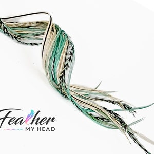 May include: A bundle of long, white, green, and black feathers. The feathers are arranged in a spiral shape. The text "Feather My Head" is visible in the lower left corner of the image.