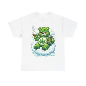 May include: White t-shirt featuring a green bear character with a cannabis leaf on its belly, smoking a cigar and holding a jar of buds. The bear is sitting on a cloud. The design is a parody of a popular children's cartoon.