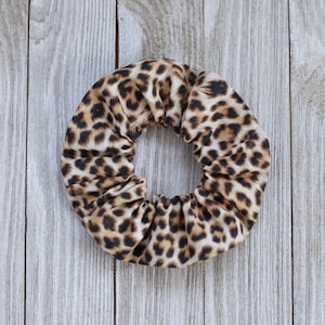 May include: A brown and tan leopard print scrunchie hair tie.