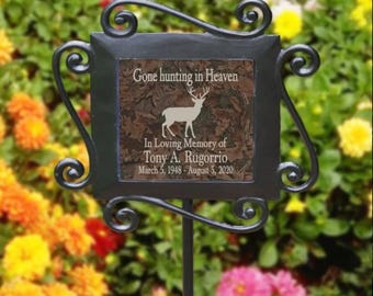 May include: A black metal garden stake with a brown and green ceramic tile. The tile has a white deer silhouette and the text "Gone hunting in Heaven. In Loving Memory of Tony A. Rugorrio. March 5, 1948 - August 5, 2020."