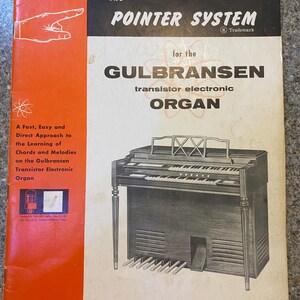 May include: Book cover for "The Pointer System" for the Gulbransen transistor electronic organ. The cover is orange and white with a black and white illustration of an organ. The text includes "Book 1" and "Price $1.75".