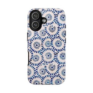 May include: A white and blue patterned phone case. The case features a repeating design of blue floral-like shapes against a white background. The phone case has a black border and a camera cutout.